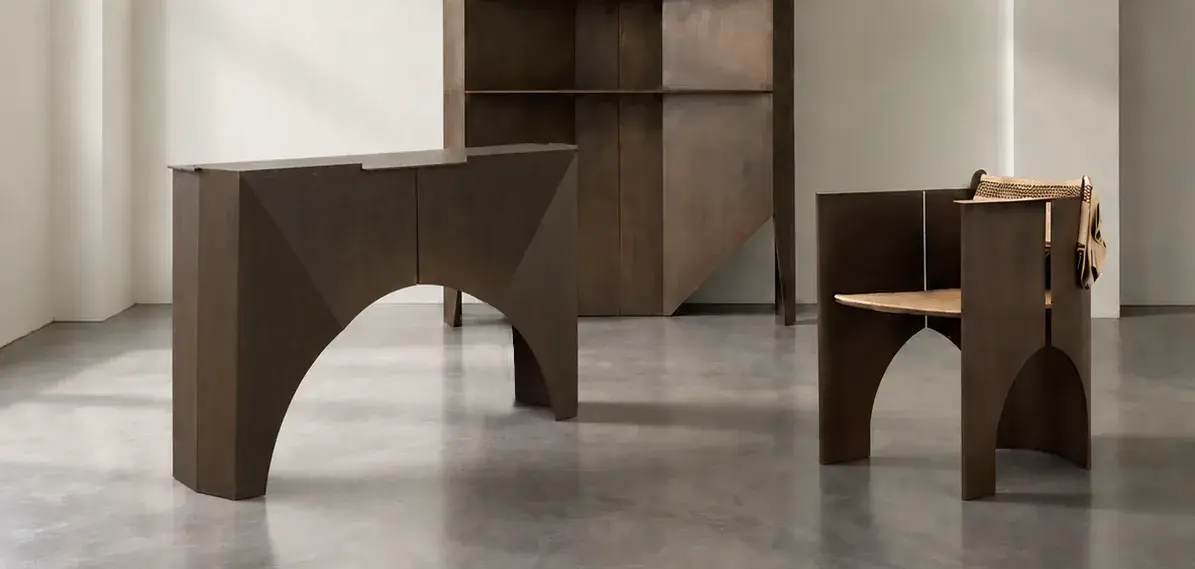 Uwerjan Collection: steel console, shelving and armchair in a timber-beamed room